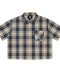 Front view of INTRV "Story" short sleeve charcoal-navy and tan plaid flannel shirt featuring a flat-hem cropped profile and diagonal patch pocket with white cursive script embroidery.